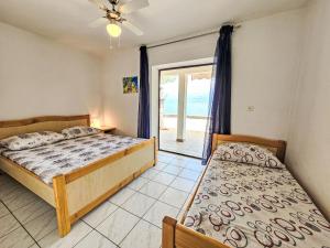 een slaapkamer met 2 bedden en een glazen schuifdeur bij Apartment Octopus-5 by Interhome in Bogomolje