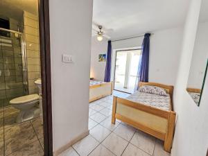 een slaapkamer met een bed en een badkamer met een toilet bij Apartment Octopus-5 by Interhome in Bogomolje +29 foto's