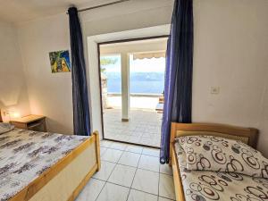 een slaapkamer met een bed en uitzicht op de oceaan bij Apartment Octopus-5 by Interhome in Bogomolje