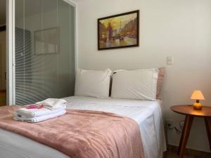 a bedroom with a white bed with a pink blanket at SH154 Descubra o Aconchego Próx Av Paulista in Sao Paulo +41 photos