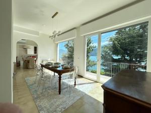 a kitchen and dining room with a table and large windows at La casa di Ersilia in Cremia