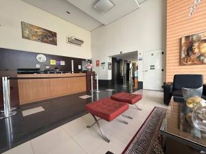 a lobby with a waiting room with a red bench and a reception desk at SH154 Descubra o Aconchego Próx Av Paulista in Sao Paulo