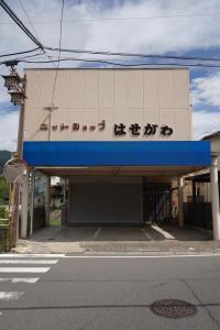 a building with a sign on the side of it at Guest House Hasegawa in Sakaki