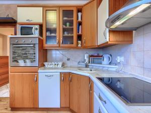 cocina con armarios de madera y lavavajillas blanco en Apartment Apartmani Amaii-1 by Interhome, en Karigador