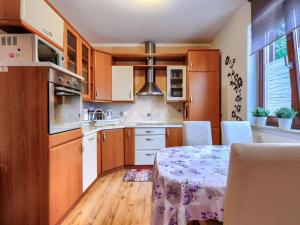 Una cocina con gabinetes de madera y una mesa con sillas. en Apartment Apartmani Amaii-1 by Interhome, en Karigador
