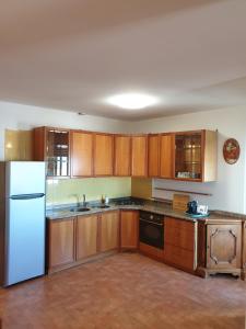 a kitchen with wooden cabinets and a white refrigerator at Nettuno apartment city center sea view in Nettuno