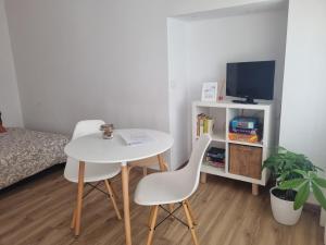 a room with a table and two chairs and a tv at Páteo Saloio in Sintra