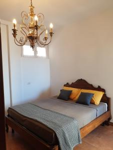 a bedroom with a bed with a chandelier at Nettuno apartment city center sea view in Nettuno