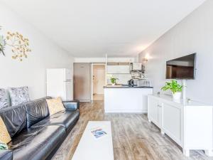 a living room with a couch and a kitchen at Apartment Les Marines-10 by Interhome in La Foux +24 photos