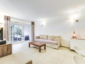 a living room with a couch and a table at Apartment Le Jardin d'Artemis-1 by Interhome in Saint-Tropez