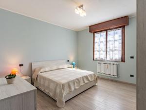 a white bedroom with a bed and a window at Apartment La Casa di Bianca by Interhome in Dongo