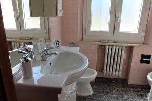 a bathroom with a sink and a toilet and windows at La casa al mare in Marcelli