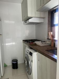 a kitchen with a washing machine and a stove at Lindo FLAT no coração de Ipanema in Rio de Janeiro
