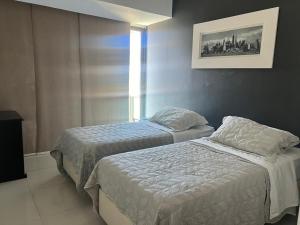 a bedroom with two beds and a window at Lindo FLAT no coração de Ipanema in Rio de Janeiro +12 photos