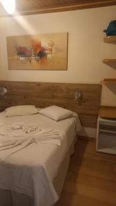 a bedroom with a bed and a painting on the wall at Pousada Eco Da Montanha in Passa Quatro