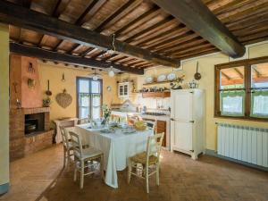 a kitchen with a table with chairs and a white refrigerator at Holiday Home La Veduta by Interhome in Montaione