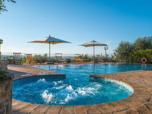 a swimming pool with umbrellas on a patio at Holiday Home La Veduta by Interhome in Montaione +37 photos
