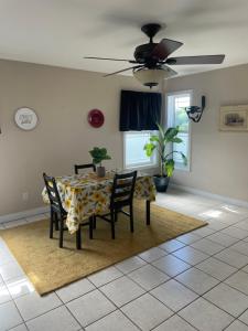a dining room with a table and chairs and a ceiling fan at Executive one bedroom apartment including pull out sofa bed in Antigonish