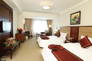 Móng Cái的住宿－雄偉壯觀芒街酒店，酒店客房配有两张床和一张书桌