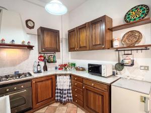 a kitchen with wooden cabinets and a microwave at Holiday Home Lidia by Interhome in Pianavia +23 photos