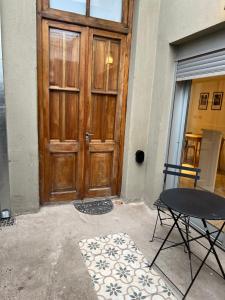 een houten deur met een tafel en een stoel voor de deur bij Loft 3 11 de Abril in Bahía Blanca