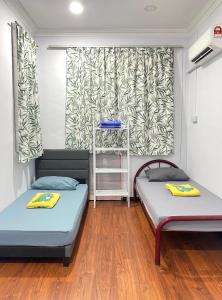 two beds in a room with a window at Home Sweet Home in Kota Kinabalu