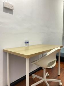 a wooden table with a chair and a bottle on it at Home Sweet Home in Kota Kinabalu
