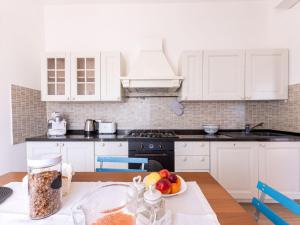 a kitchen with white cabinets and a table with a bowl of fruit at Holiday Home Podere Cavaceppi by Interhome in Pitigliano +38 photos