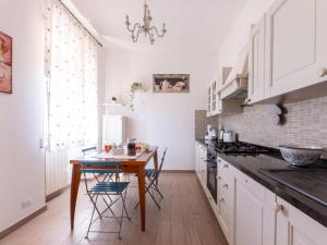 a kitchen with white cabinets and a table and chairs at Holiday Home Podere Cavaceppi by Interhome in Pitigliano