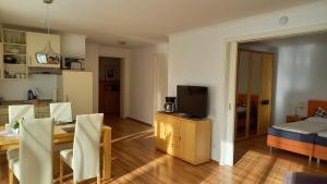 a living room with a dining table and a television at Wellness Ferienwohnung mit Bademantelgang zur Therme in Bad Griesbach +4 photos