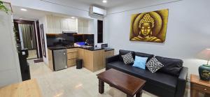 Una sala de estar con un sofá y una cocina. en C&C Jayakarta Apartment Legian Kuta Bali, en Seminyak