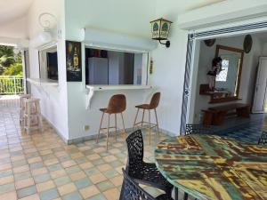 una cucina e una sala da pranzo con tavolo e sedie di Villa Muscade guadeloupe, piscine, vue mer et accès plage a Saint-François