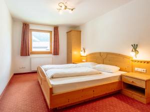 1 dormitorio con cama de madera y ventana en Apartment Nr- 7 by Interhome, en Solda