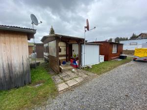 a small shed with a house in a yard at Schlichtes und gemütliches Mobilhome 114 in Boltigen