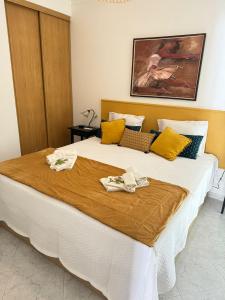 1 dormitorio con 1 cama grande y toallas. en Tavira Sea view - Yellow Apartment en Tavira