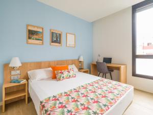 ein Schlafzimmer mit Bett, Schreibtisch und Fenster in der Unterkunft VIVENTE - Viviendas Vacacionales in Guanarteme