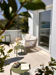 a patio with a couch and a table and chairs at Vireo Rooms in Santa Maria Navarrese