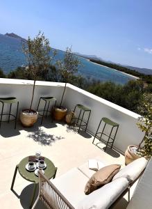 a patio with a couch and tables and the ocean at Vireo Rooms in Santa Maria Navarrese +37 photos