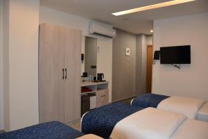 a hotel room with two beds and a tv at MyFlower 3 Hotel in Erbil