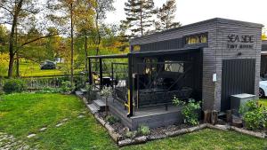 a small black shed with a porch in a yard at Sea Side, Tiny House 13 in Salzhemmendorf