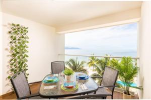 a dining room with a table and chairs and a large window at Serene Beachfront Escape Includes Delicious Breakfast in Puerto Vallarta