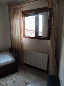 ein kleines Schlafzimmer mit Fenster, Bett und Heizkörper in der Unterkunft Arachova Cozy in Arachova