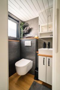 a bathroom with a white toilet and a sink at Sea Side, Tiny House 13 in Salzhemmendorf