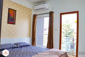 a bedroom with a bed next to a window at Staymazing Ferndale-1 & 2 BHK Boutique AC Serviced Apartments in Bengaluru