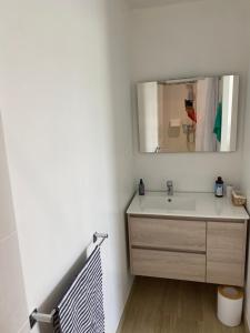 a bathroom with a sink and a mirror at Chambre d'hôtes près de la plage in Pornichet