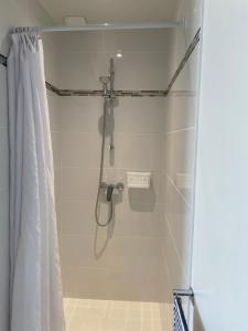 a shower in a bathroom with a shower curtain at Chambre d'hôtes près de la plage in Pornichet