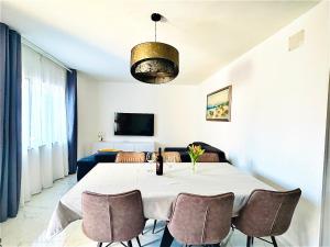 a dining room with a white table and chairs at Apartments with parking space Povljana, Pag - 228 in Povljana +10 photos
