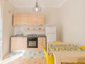 a small kitchen with a table and a refrigerator at Casa Vacanze Ginevra in Mandra Capreria