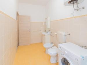 a bathroom with a toilet and a washing machine at Casa Vacanze Ginevra in Mandra Capreria +15 photos