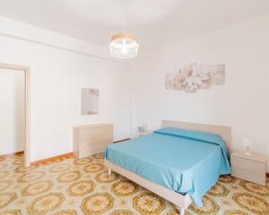 a bedroom with a blue bed in a white room at Casa Vacanze Ginevra in Mandra Capreria